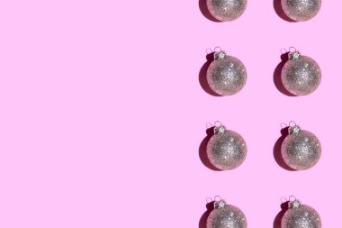 Pembe arka planda gümüş toplarından yapılmış desen.