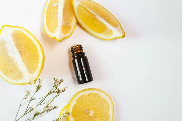 Duas garrafas de óleo essencial de limão no fundo branco — Fotografia de Stock