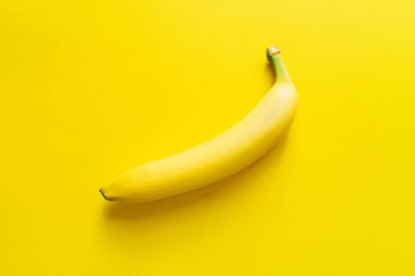 Sarı bir arka plan üzerinde bir olgun muz.