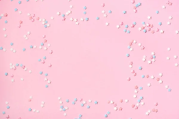 Konfety ve formě malých hvězd na růžovém pozadí. — Stock fotografie