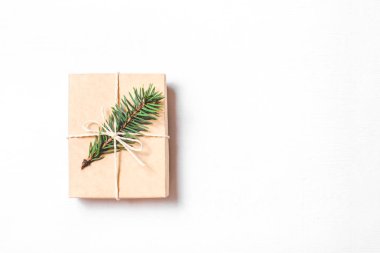 Beyaz arkaplanda köknar dalı olan bir Noel hediyesi.