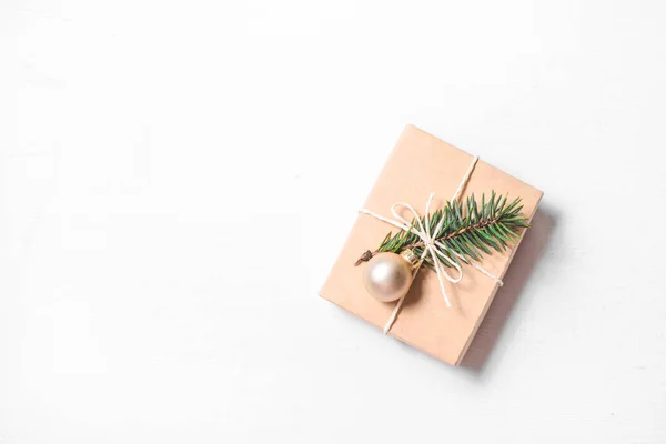 Presente de Natal com ramo de abeto no fundo branco. — Fotografia de Stock