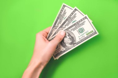 Yeşil arka planda kadın el Dolar.