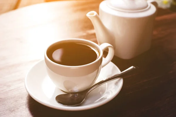 Tetera y taza de té sobre mesa de madera. — Foto de Stock