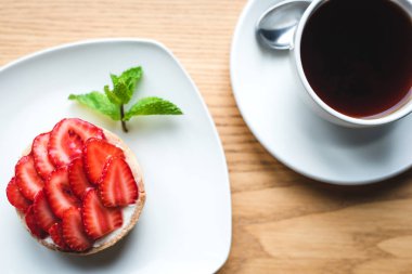 Çilek tartlet ve bir fincan çay.