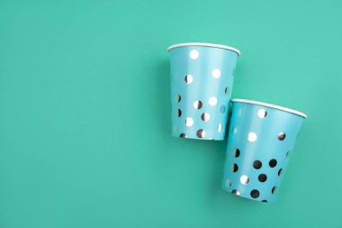 Nane arka plan üzerinde iki mavi kağıt bardak.