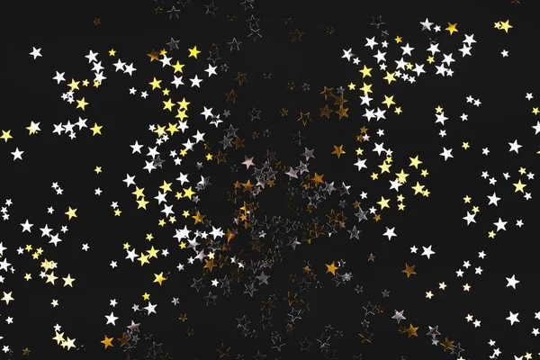 Estrelas douradas e prateadas sobre fundo preto . — Fotografia de Stock