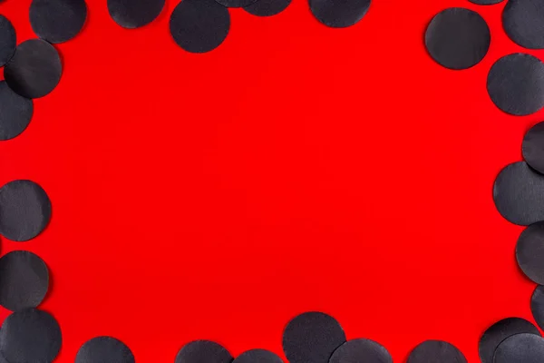 Červené pozadí s černými konfety. — Stock fotografie