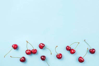 Mavi arka planda olgun kirazların parlak deseni.