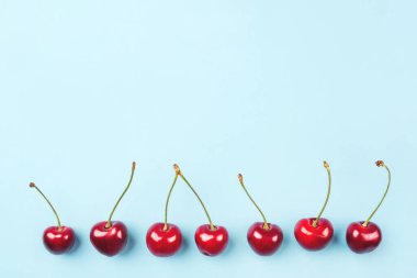 Mavi arka planda olgun kirazların parlak deseni.