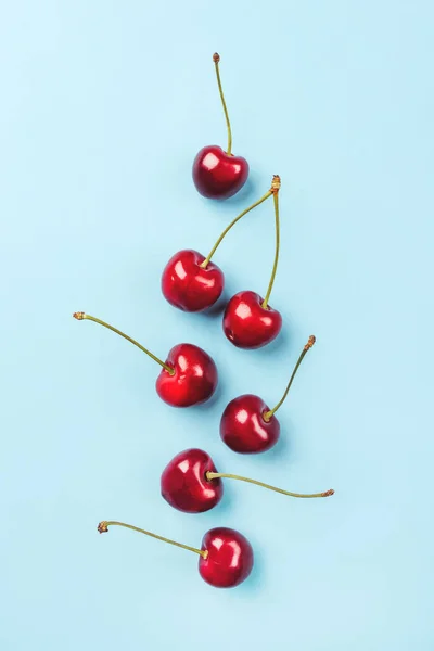 Composition of ripe cherries on a blue background. — Stock Photo, Image