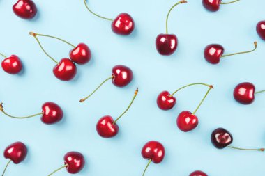 Mavi arka planda olgun kirazların parlak deseni.