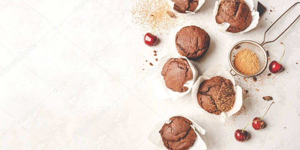 Homemade fresh chocolate muffins with berries and chocolate pieces.