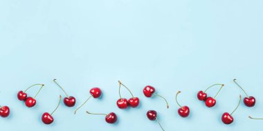 Mavi arka planda olgun kirazların parlak deseni.