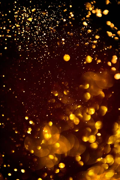 Goldenes abstraktes Bokeh auf schwarzem Hintergrund. — Stockfoto