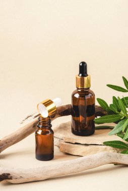 Doğal bej arka planda iki kahverengi kozmetik şişesi..