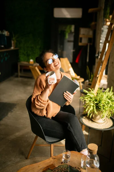 Chica blogger con una taza de café en la cafetería con revista — Foto de Stock