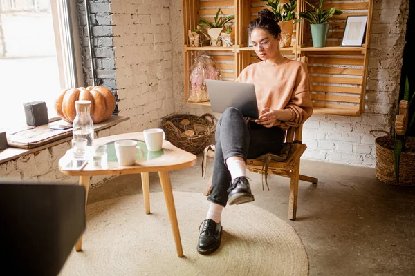 Giovane donna seduta con computer portatile in caffè — Foto Stock