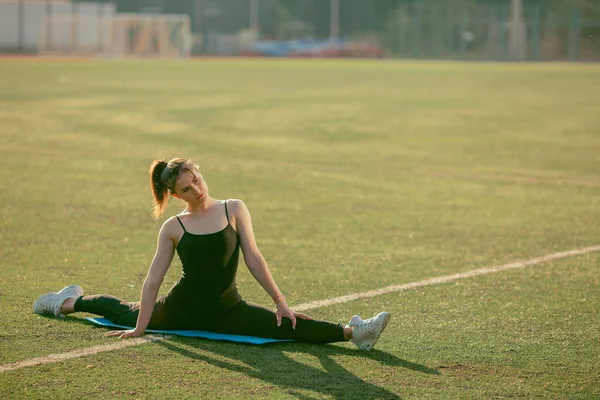 足ストレッチ スポーツウェアを行う美しいフィット女性 夏の公園の屋外で平らな腹を持つ筋肉のスリム魅力的な女の子 ボディケア フィットネス スポーティライフコンセプト — ストック写真