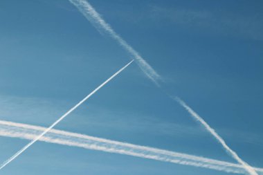 Chemtrails ve mavi gökyüzünde uçan uçak