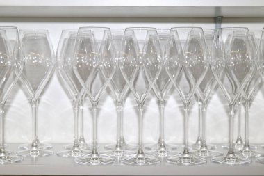 Restoran dolabında bir sürü boş kristal bardak var.