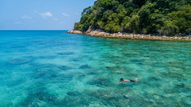 Yalnız açık mavi kristal su ile mercan resif üzerinde bir tropikal deniz şnorkel adam. Perhentian Adası, Malezya