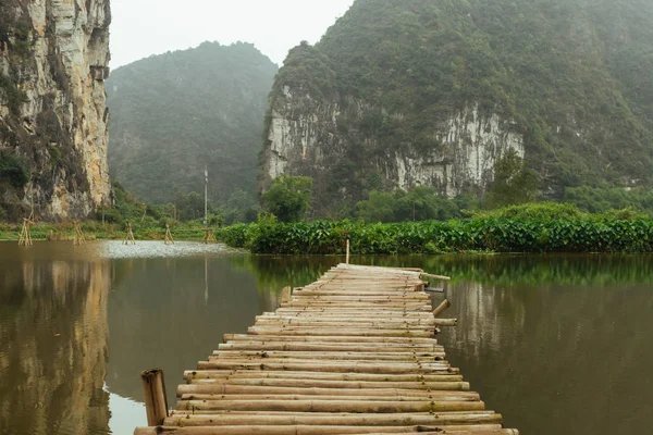 Гірський ландшафт з деревським мостом і озером, Ninhbinh, В'єтнамська Панорама в Транг — стокове фото