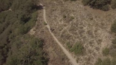Kırsal arazide binici bisiklet parkuru. Havadan yukarıdan aşağıya drone'dan ateş