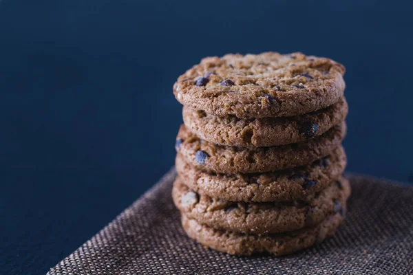 Biscoitos de chocolate feitos à mão empilhados de aveia em placa de ardósia preta isolada — Fotografia de Stock