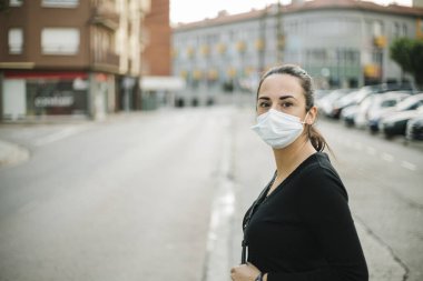 Coronavirus önleme için tıbbi maske takan genç bir kadın.