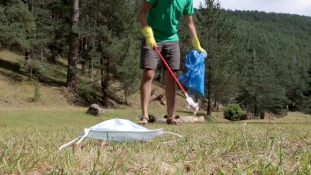 Man Pikt Een Masker Met Een Grijper Het Bos Tijdens — Stockvideo