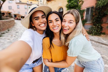 İtalya 'da yaz tatili boyunca şehirde birlikte eğlenen üç çok ırklı kadının selfie portresi. Tatil yaşam tarzı ve kadın arkadaşlık kavramı