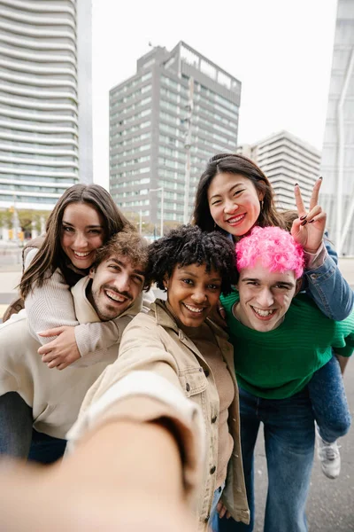 Şehir caddesinde selfie çeken mutlu gençler. Milenyum kuşağı arkadaşları dışarıda eğlenirken gülüyorlar. Arkadaşlık yaşam tarzı konsepti