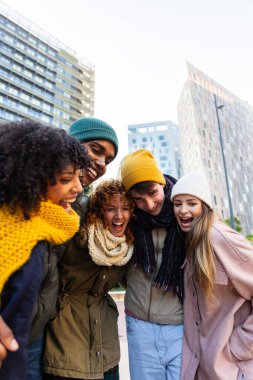 Young students enjoying winter outdoors, having fun sharing laughter and friendship. Moments of joy and togetherness in the city. Student lifestyle concept.