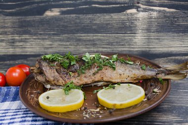 Deniz sebze ahşap arka plan üzerinde balıkla pişmiş