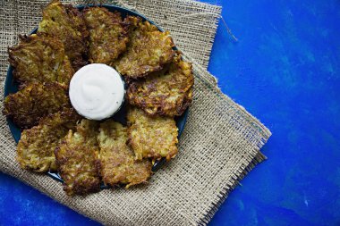 Mavi bir arka plan üzerinde soslu patates börek. Yukarıdan görüntülemek.