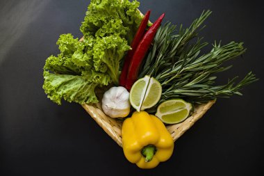 Karanlık bir arka plan üzerinde bir sepet içinde taze sebze. Doğru beslenme. Yan görünüm.