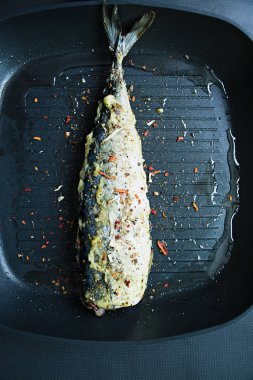 Balık için baharat ile dekore edilmiş kızarmış uskumru ızgara tavası. Koyu arka plan. Yukarıdan görüntülemek