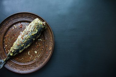 Bir teralka üzerinde kızarmış uskumru balık için baharat ile dekore edilmiştir. Koyu arka plan. Yukarıdan görüntülemek.