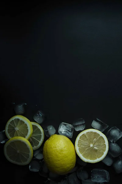 Sliced lemon with ice on a dark background. Place for text. View from above. — Stock Photo, Image
