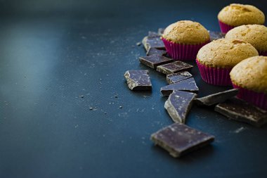 Siyah koyu arka plan üzerinde çikolata parçaları ile vanilyalı kek. Yan görünüm.