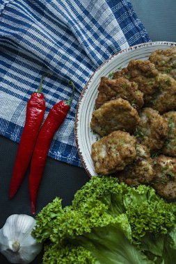 Domuz pirzola Yeşiller ve sebze siyah bir arka plan ile bir tabakta. Yukarıdan görüntülemek
