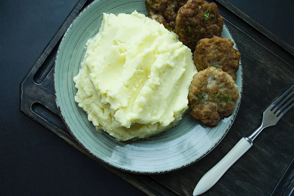 Pork cutlets with mashed potatoes, greens on a black background. View from above. — Stock Photo, Image