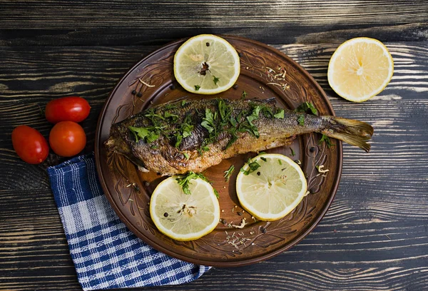 Ahşap arka planda sebzeli kızarmış dorada balığı.
