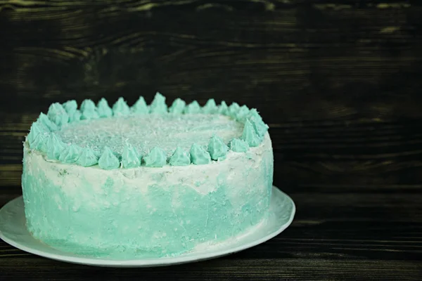 Ombre green cake for celebration on a dark wooden background