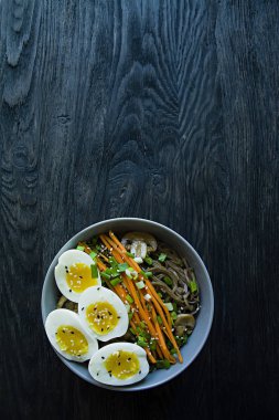 Buğday soba noodle soslu ve yan yemekler bouillon içinde. Japon yemekleri. Asya mutfağı. Siyah ahşap arka plan. Metin için yer. Yukarıdan görüntülemek.