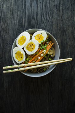 Buğday soba noodle soslu ve yan yemekler bouillon içinde. Japon yemekleri. Asya mutfağı. Siyah ahşap arka plan. Yukarıdan görüntülemek.