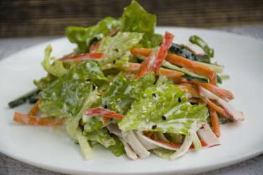 Diyet gıda, imitasyon yengeç sopa, soya sosu ve Japon susam ile taze sebze salatası. Şeritler halinde kesin. Koyu ahşap arka plan. Yukarıdan görüntülemek.