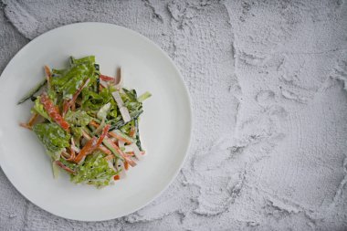 Diyet gıda, imitasyon yengeç sopa, soya sosu ve Japon susam ile taze sebze salatası. Şeritler halinde kesin. Koyu ahşap arka plan. Yukarıdan görüntülemek.