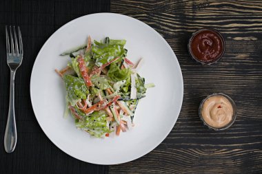 Diyet gıda, imitasyon yengeç sopa, soya sosu ve Japon susam ile taze sebze salatası. Şeritler halinde kesin. Koyu ahşap arka plan. Yukarıdan görüntülemek.